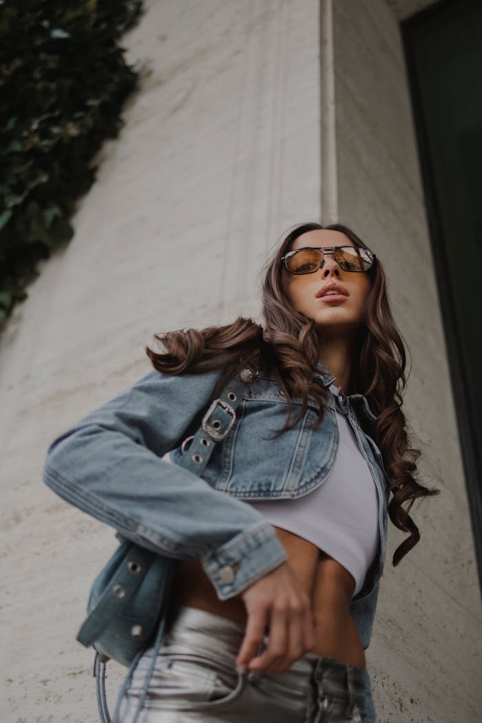 gallery-03 Stylish woman posing in a denim jacket, sunglasses, and crop top with modern vibes.